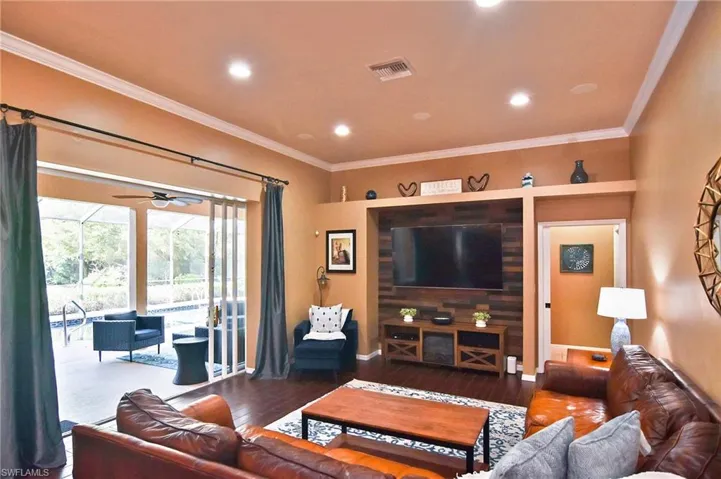 Living room with ornamental molding, hardwood / wood-style floors, ceiling fan, a sunroom, and recessed lighting