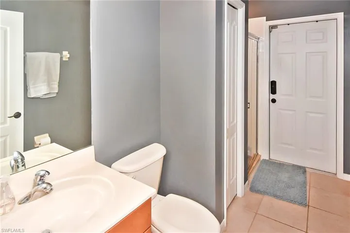 Full bath featuring vanity, a shower stall, and light tile patterned flooring