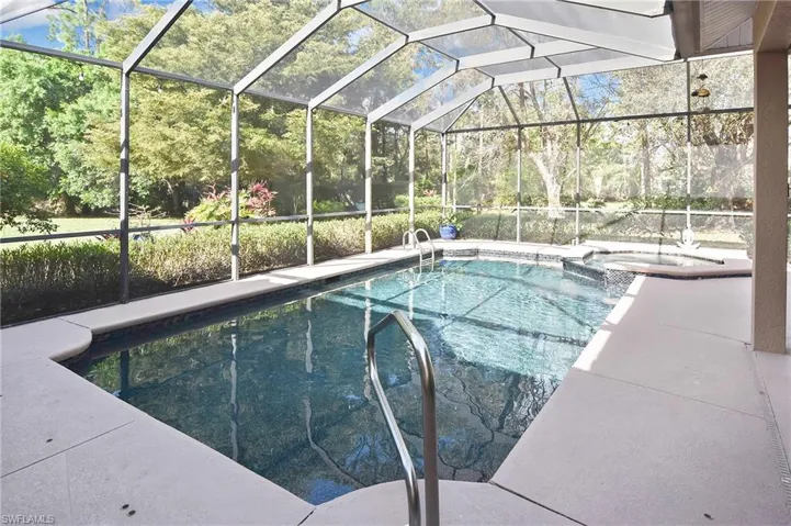 Combined pool / hot tub with a lanai, a sunroom, and a patio area