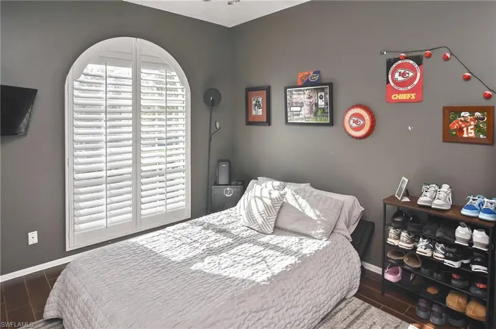 Bedroom with baseboards and dark wood-type flooring
