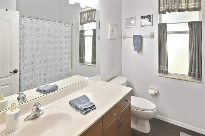 Bathroom featuring vanity, a shower with shower curtain, and dark wood-style floors