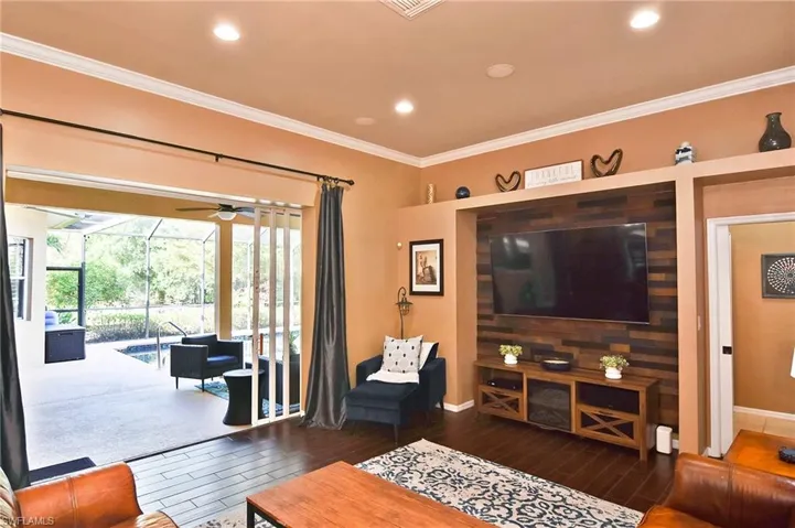 Living area with a sunroom, crown molding, wood finished floors, a ceiling fan, and recessed lighting