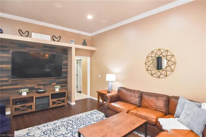 Living area with crown molding, wood finished floors, and recessed lighting