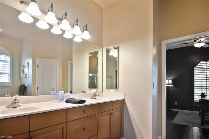 Full bathroom with double vanity, ceiling fan, and light wood-type flooring