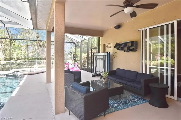 View of patio featuring outdoor lounge area, a sunroom, a ceiling fan, and a pool with connected hot tub