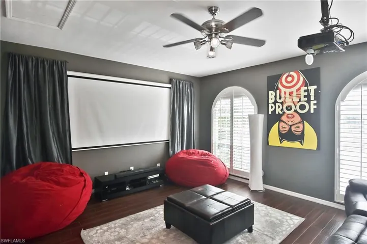 Cinema room featuring dark wood-style flooring and a ceiling fan