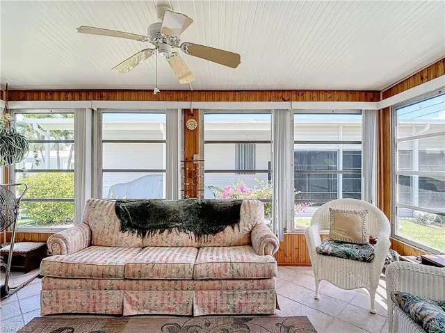 Sunroom / solarium featuring wood ceiling and ceiling fan