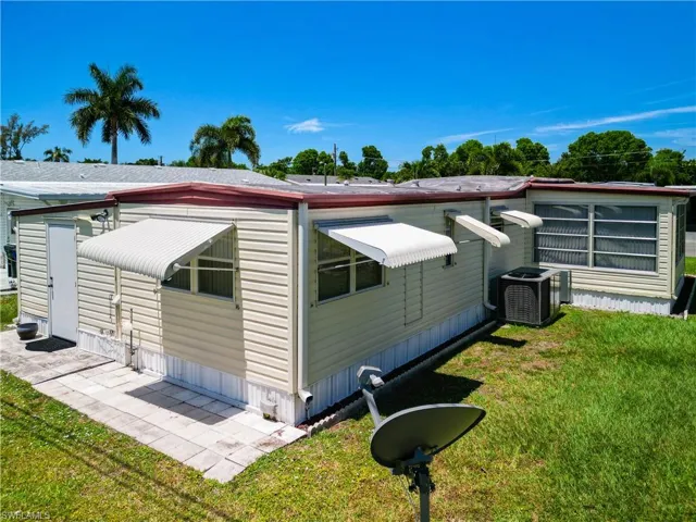 View of side of home with a lawn and central air condition unit