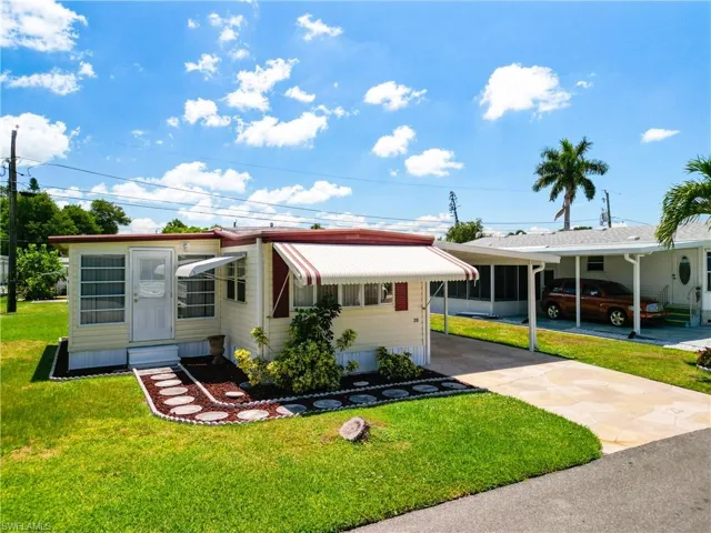 View of front of home featuring a front yard and a carport