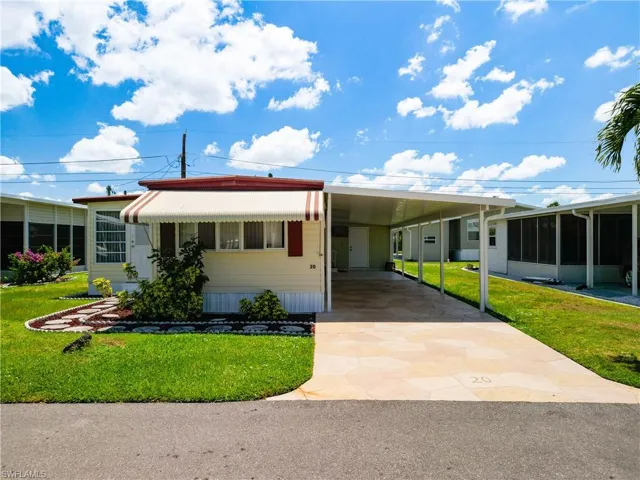 Manufactured / mobile home with a carport and a front yard