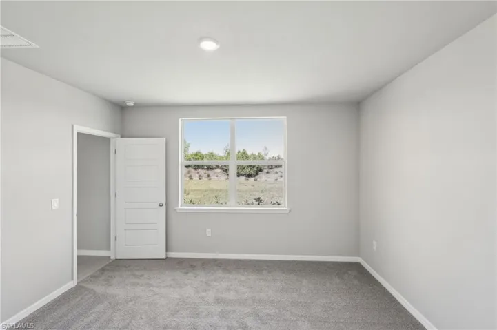 Empty room featuring carpet flooring and baseboards