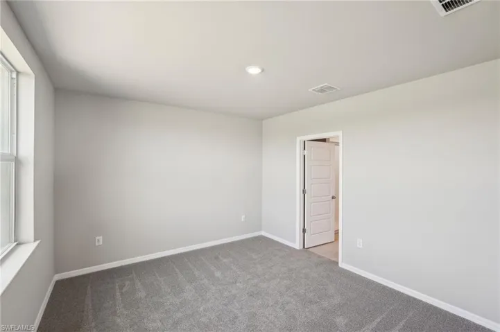 Empty room with baseboards, carpet, visible vents, and recessed lighting