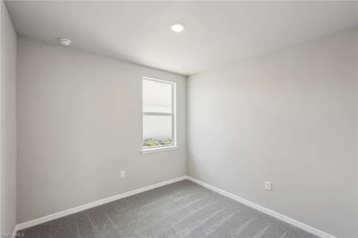 Unfurnished room featuring baseboards and carpet