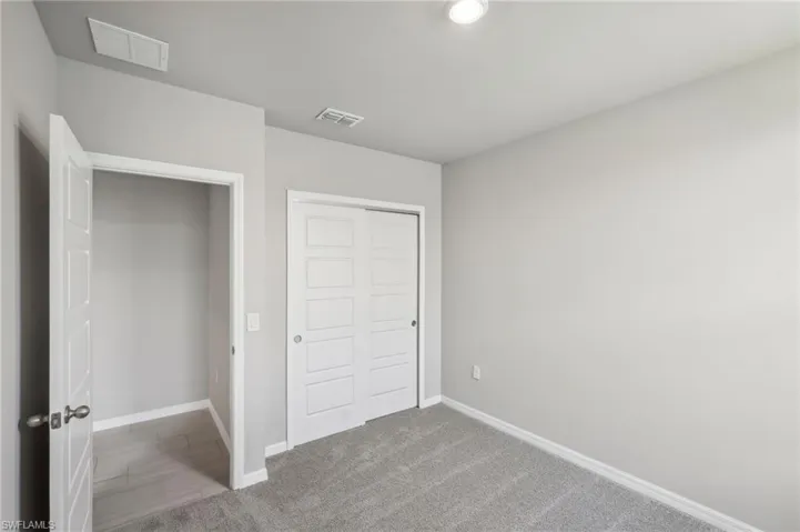 Unfurnished bedroom featuring visible vents, baseboards, and a closet