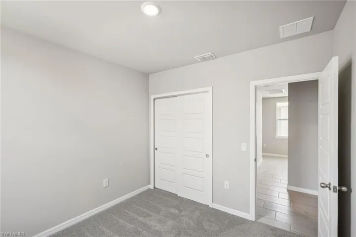Unfurnished bedroom featuring a closet, baseboards, and visible vents