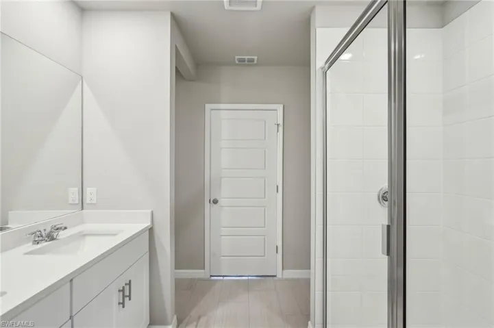 Full bathroom with vanity, visible vents, baseboards, and a stall shower