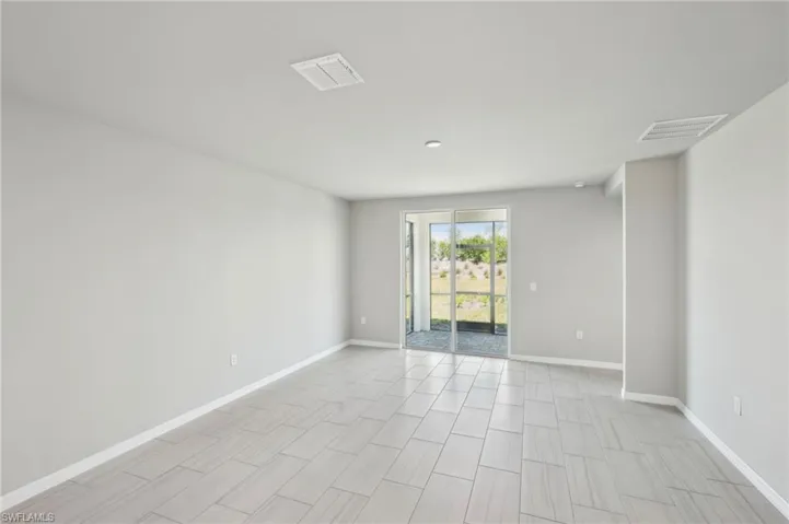 Unfurnished room featuring visible vents and baseboards