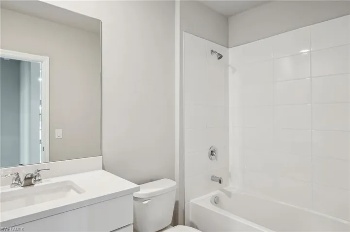 Bathroom with shower / bathtub combination, vanity, and toilet