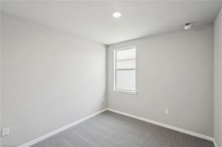 Carpeted empty room featuring baseboards