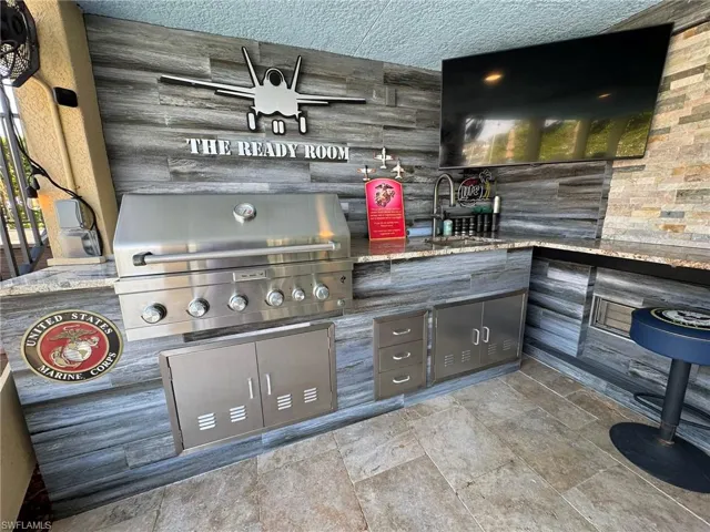 View of patio with area for grilling, sink, and grilling area
