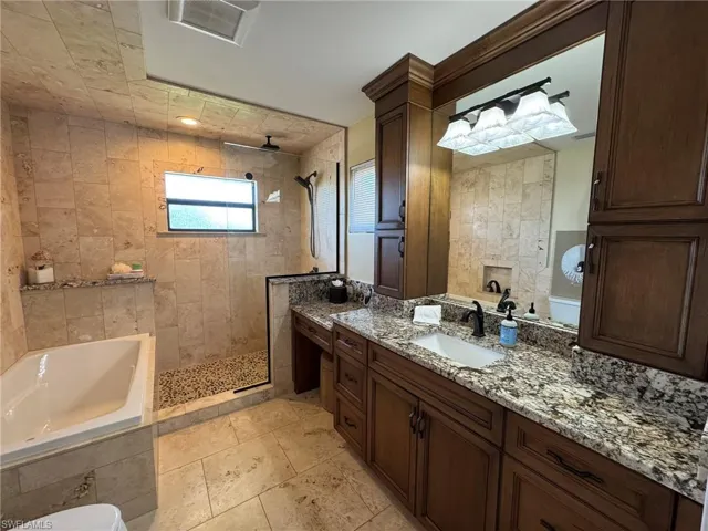 MASTER Bathroom featuring ceiling fan, vanity, and plus walk in shower