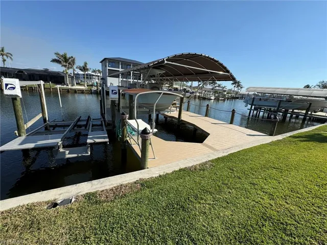 Dock area with a lawn and a water view