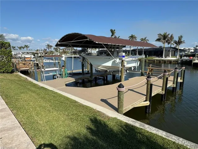 Dock area with a lawn and a water view
