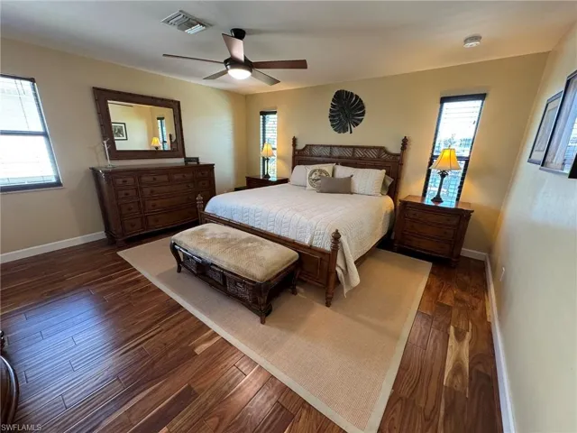 MASTER Bedroom with ceiling fan, dark hardwood / wood-style flooring, and multiple windows