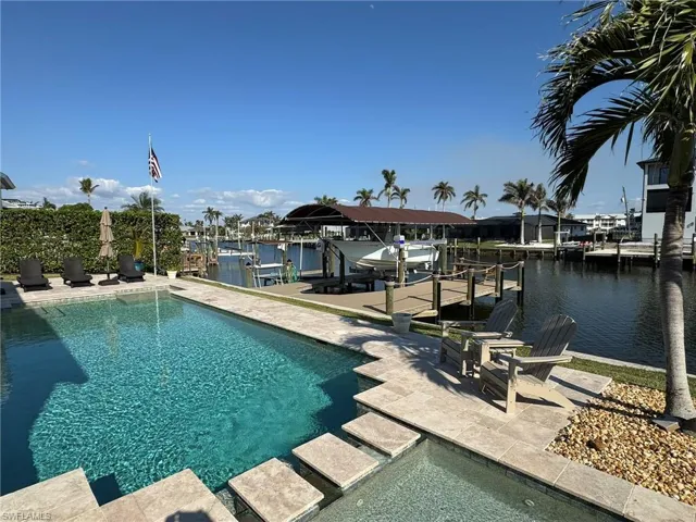 View of swimming pool featuring a water view and a boat dock
