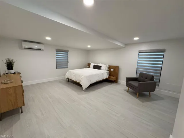 4TH Bedroom with light hardwood / wood-style floors and a wall mounted AC