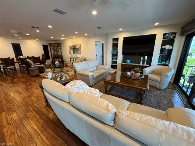 Living room with dark wood-type flooring and ceiling fan