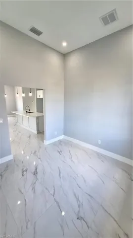 Spare room featuring a sink, baseboards, and visible vents