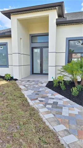 Property entrance featuring stucco siding and french doors