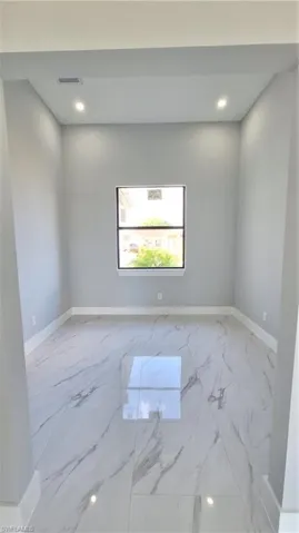 Spare room with baseboards, marble finish floor, visible vents, and recessed lighting