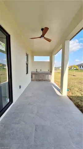 View of patio with ceiling fan and an outdoor kitchen