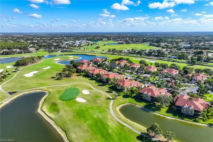 Aerial view of residential area featuring a golf club and a large body of water