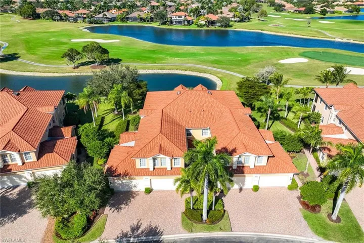 Aerial view of residential area featuring a large body of water and a local golf course