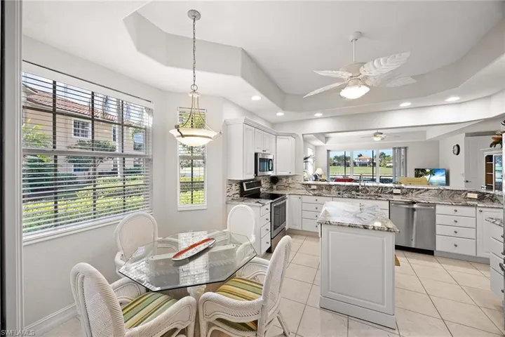 Kitchen featuring white cabinetry, light stone countertops, stainless steel appliances, and light tile patterned floors