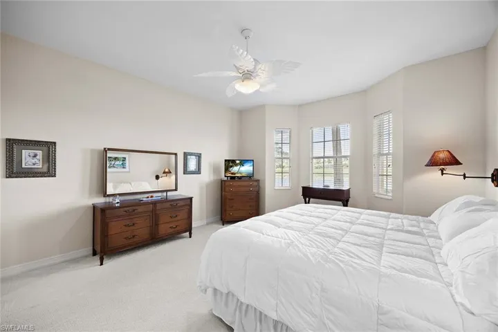Bedroom with light colored carpet and a ceiling fan