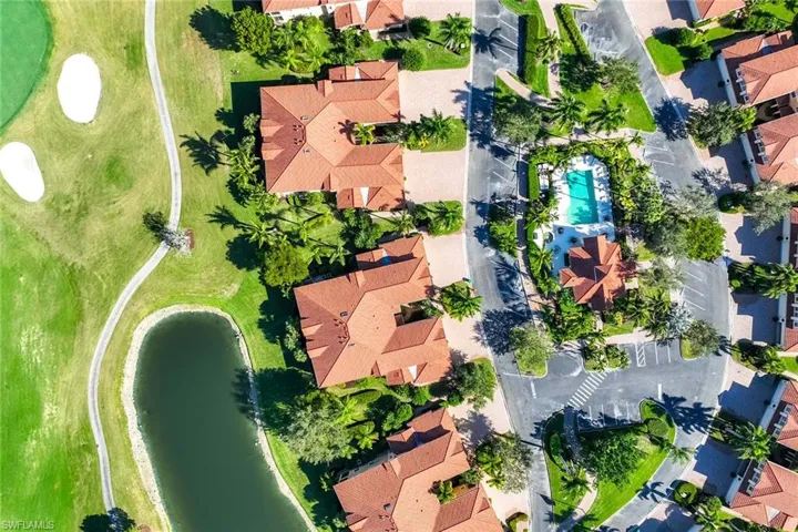 Aerial perspective of suburban area featuring a local golf course and a large body of water