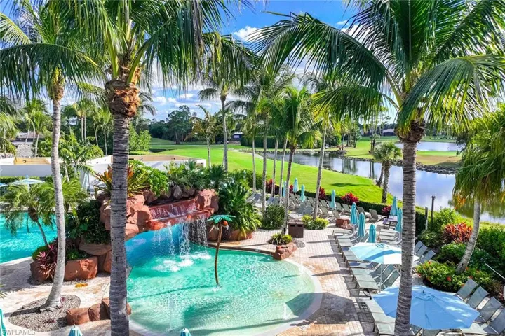 Community pool featuring a patio, a water view, and a lawn