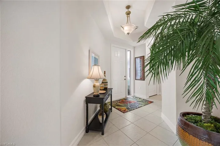 Foyer featuring light tile patterned floors and a tray ceiling