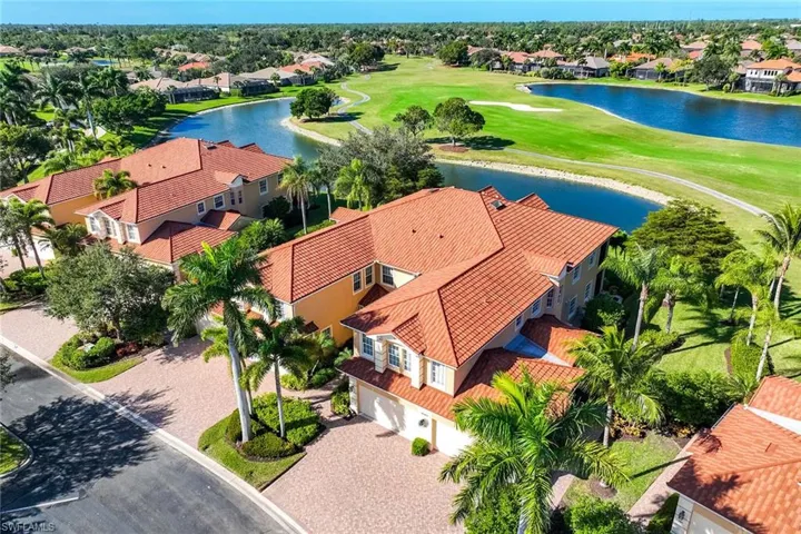 Aerial perspective of suburban area with a nearby body of water and a local golf course