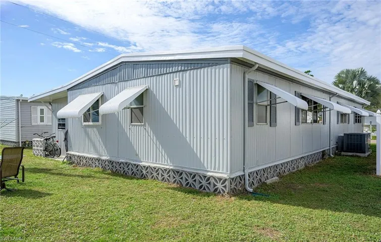 View of side of home with a lawn and central AC unit