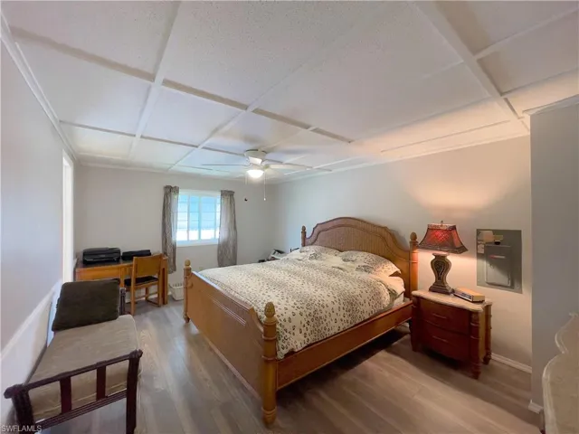 Bedroom featuring coffered ceiling, ceiling fan, and dark hardwood / wood-style floors