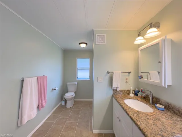 Bathroom featuring tile patterned floors, vanity, and toilet