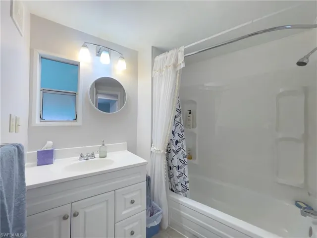 Bathroom with shower / tub combo with curtain and vanity