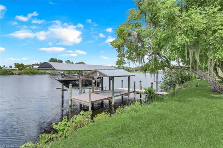 Dock area featuring a water view and a yard