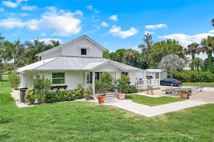 Back of property featuring a yard and covered porch
