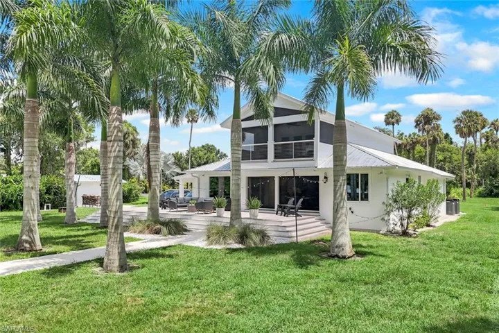 Rear view of house with a lawn and a patio